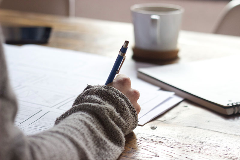 Business graduate writing a job application at their desk